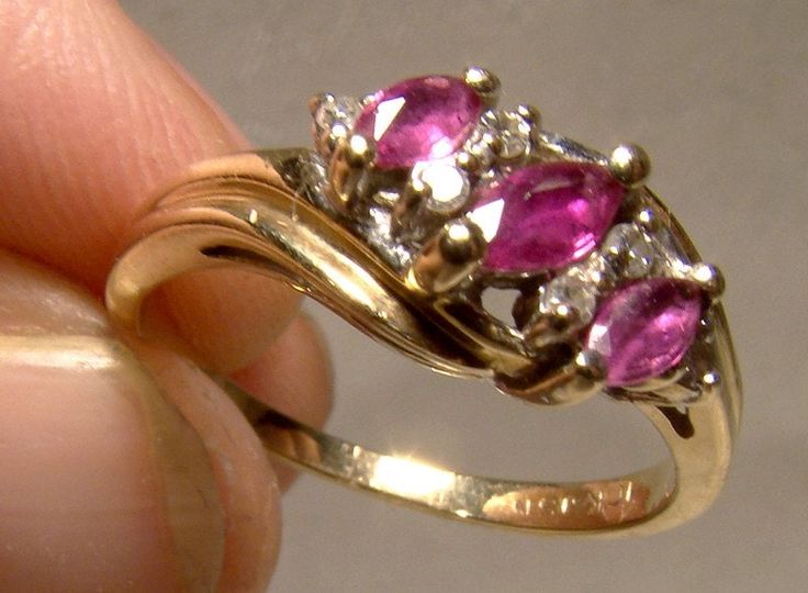 A 10k three ruby marquise and diamonds row ring from the 1970s.  This vintage size 7 yellow gold ring features two pink marquise cut rubies and six single point diamonds as highlights in a graceful swirl.  One of the of the pink gems tests as a topaz, so that most likely is a replacement stone. It is well matched to the others.  This ring weighs 2.9 grams, it is stamped 10K and JSN and it is in excellent condition with no dents, bends, corrosion, losses, damage or repairs other than the possibly Pink Marquise Cut Ruby Ring For Anniversary, Antique Ruby Ring, Pink Gem, Ruby Jewelry, Yellow Gold Ring, Multi Stone Ring, Marquise Cut, Multi Stone, Diamond Earrings Studs