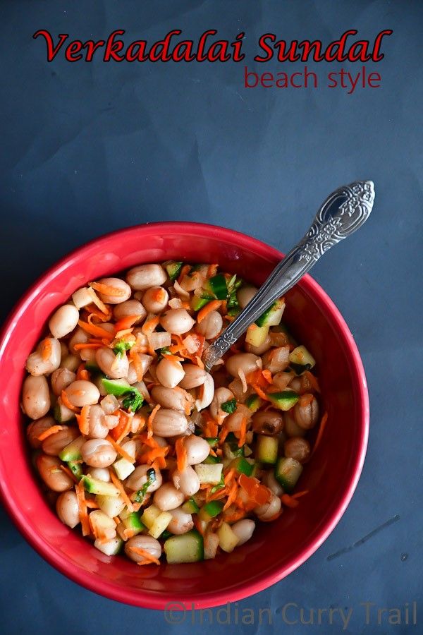 a bowl filled with beans and carrots on top of a blue tablecloth next to a spoon