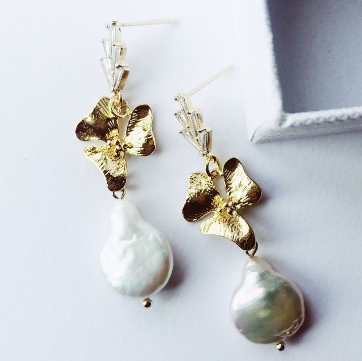 Handcrafted freshwater pearl earrings. Beautiful statement earrings for any occasion.  24K gold plated with faceted zircona crystal ear posts.   Hand-wired gold floral elements and freshwater pearl drops with incredible lustre. All freshwater pearls are unique and as such there will never be an exact match, each pair will have beautiful irregularities. Earring drop 5cm  All of our accessories are beautifully packaged in luxury boxes with acid-free tissue paper, tied with exclusive Garter & Veil grosgrain ribbon. SHOP MORE STYLES. www.garterandveil.etsy.com FIND ME ON www.instagram.com/garterandveil All orders sent within the UK are sent via signed for 1st class signed for. International orders will be sent tracked and signed where possible. Bridal Earrings Gold, Elegant Wedding Jewelry, Pearl Bridal Earrings, Jewelry For Brides, Wedding Jewelry For Bride, Gold Bridal Earrings, Wedding Guest Hairstyles, Earring Drop, Freshwater Pearl Earrings