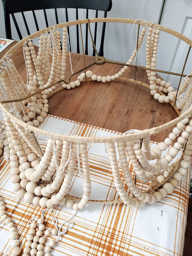 a wooden beaded necklace is sitting on a table with a chair in the background