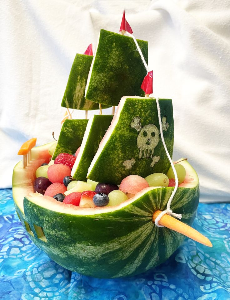 a watermelon boat made to look like a pirate ship with fruit in it