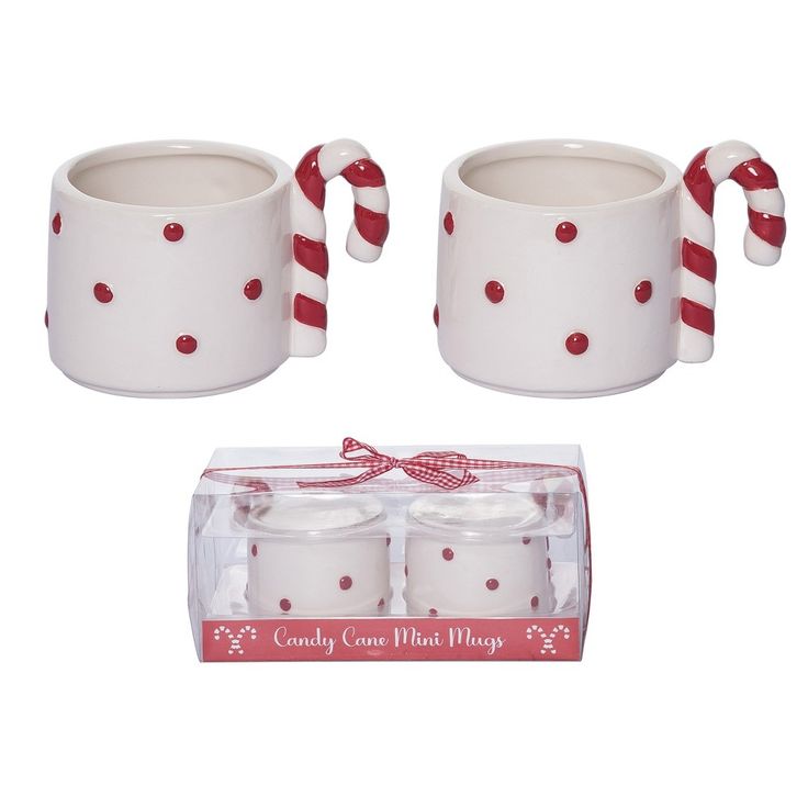 two white ceramic mugs with candy cane handles and red polka dot design on them