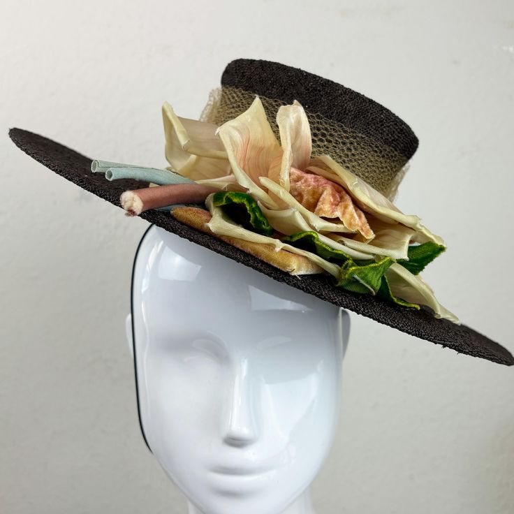 Beautiful 1940s textured brown straw tilt boater style hat with "Original by Rose Saphire Hats" label. Shop was located at 501 Madison Avenue in NYC.  Material is a chocolate brown textured straw with an airy weave. Tall crown is wrapped with yellow/tan tulle. Large pastel colored millinery floral ornament on left side made of satin and velvet. There is an elastic strap as this hat is designed to perch on your head.  Condition: Excellent.  Size: Brim is 13.75" in diameter.  Crown height: 3.5"  I Fitted Brown Boater Hat For Kentucky Derby, Handmade Fitted Vintage Fascinator, Handmade Vintage Hat Bands For Kentucky Derby, Handmade Vintage Hat-style Fascinator, Handmade Vintage Hat Fascinator, Handmade Vintage Hat Bands, Vintage Fedora Straw Hat For Garden Party, Vintage Straw Hat For Royal Ascot Garden Party, Vintage Straw Hat For Garden Party And Royal Ascot