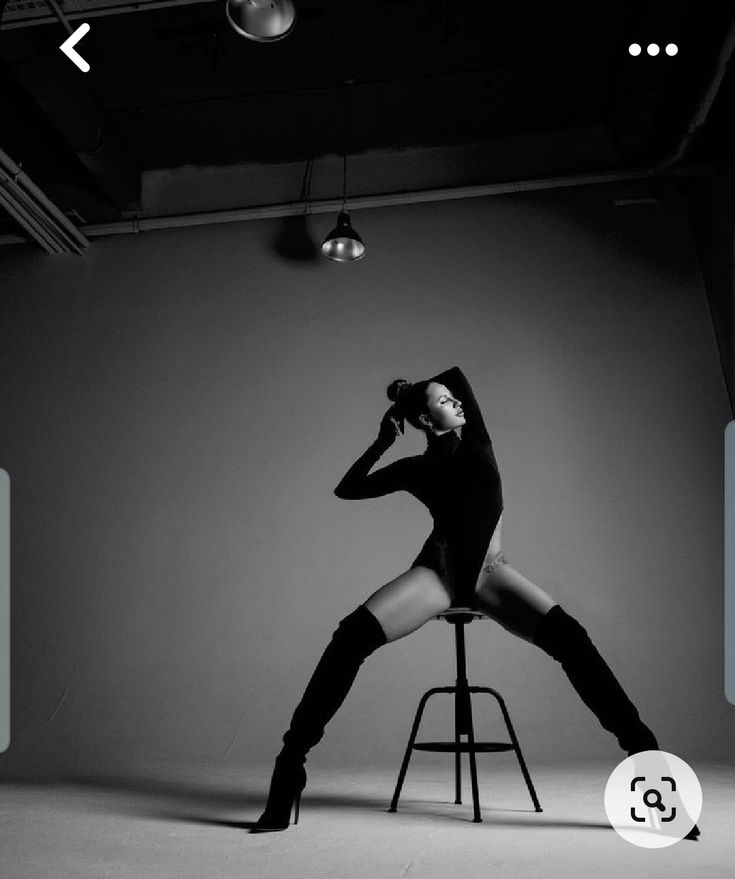 a woman sitting on top of a stool wearing high heeled boots and black stockings