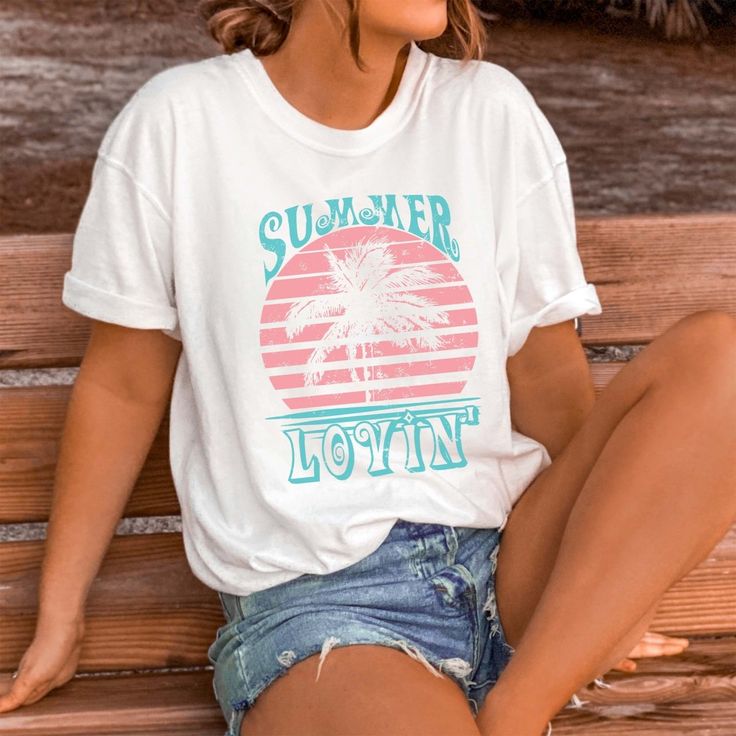 Bask in the warmth of summer with our "Summer Lovin'" Tee. Crafted for those who adore the sun-kissed days and balmy nights of the season, this tee is your perfect companion for soaking up all the love summer has to offer. Made from premium materials, our tee ensures both comfort and durability, ideal for all your summer adventures. The charming "Summer Lovin'" design evokes feelings of carefree bliss and romantic sunsets, capturing the essence of summer romance. Whether you're strolling along t Popular Graphic Tees, Heather Storm, Romantic Sunset, Travel Tees, Summer Romance, Outdoor Concert, Columbia Blue, Cut Off Jeans, Boyfriend Style