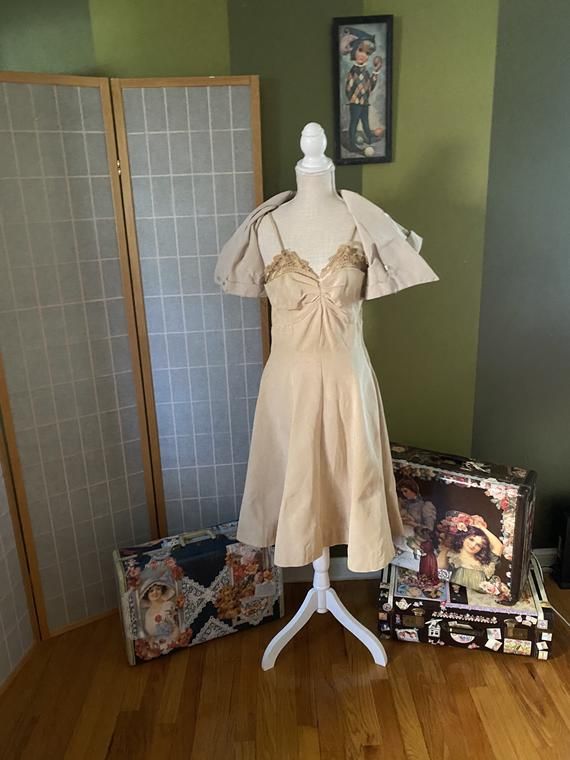 Very cool 1950’s beige formal dress with matching bolero. Both are made of a very heavy fabric. Weird, but the dress and jacket are not the same color, dress is a bit more yellow than jacket. Bolero does not have its buttons. Dress has a sizable water stain on the skirt as well as a couple smaller stains, and the bodice is pretty stained and discolored, likely from sweat?? Definitely needs some TLC, but is totally structurally sound and unique. Being sold as isWomen’s size smallDressBust: 35”Wai Cream Vintage Dress For Spring Party, Beige Evening Dress With Lined Bodice, Beige Evening Dresses With Lined Bodice, Fitted Vintage Maxi Dress For Evening, 1950s Style Spring Wedding Dresses, Spring Vintage Fitted Evening Dress, Chic Fitted Vintage Dress In Beige, Elegant Vintage Dresses For Spring, Elegant Beige Vintage Dress For Party