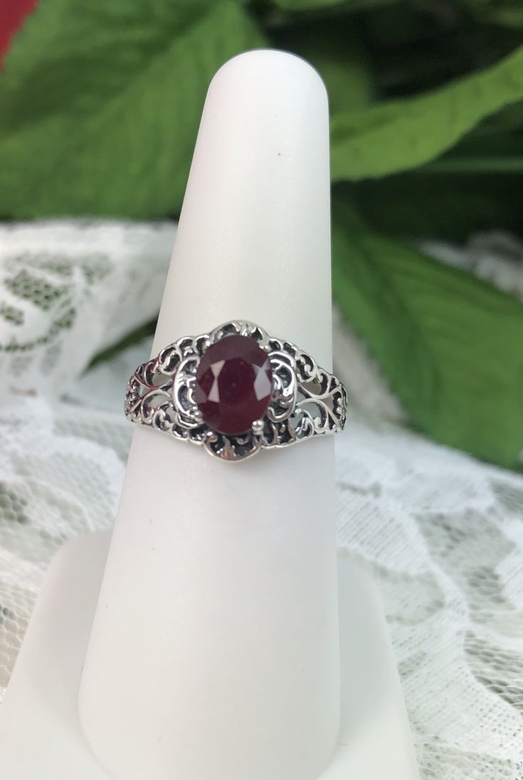 Natural Red Garnet Ring Description Small Nouveau Design#14 MADE TO ORDER Inspired by Victorian and Art Nouveau designs I now offer this stunning Antique reproduction in sterling silver. This gorgeous ring is set with a natural ruby gemstone. The stunning gemstone is 8mm (5/16th of an inch) in length by 6mm (1/4th of an inch) in width; approximately 1.34ct. Notice the beautiful intricate design of the silver filigree setting and trellis band. Notice the beautiful floral filigree craftsmanship of Oval Ruby Gemstones With Center Stone, Oval Ruby Ring With Center Stone In Sterling Silver, Oval Ruby Ring With Prong Setting In Sterling Silver, Oval Ruby Gemstones With Accent Stones, Oval Ruby Ring With Prong Setting, Oval Ruby Promise Ring, Oval Ruby Jewelry With Center Stone, Oval Ruby Ring In White Gold For Gift, Oval Ruby Ring In White Gold Sterling Silver