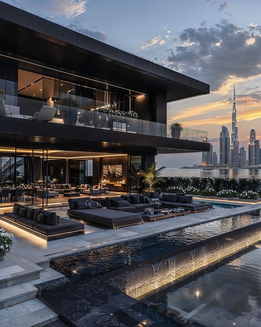 an outdoor living area with couches, tables and water features in front of the city skyline