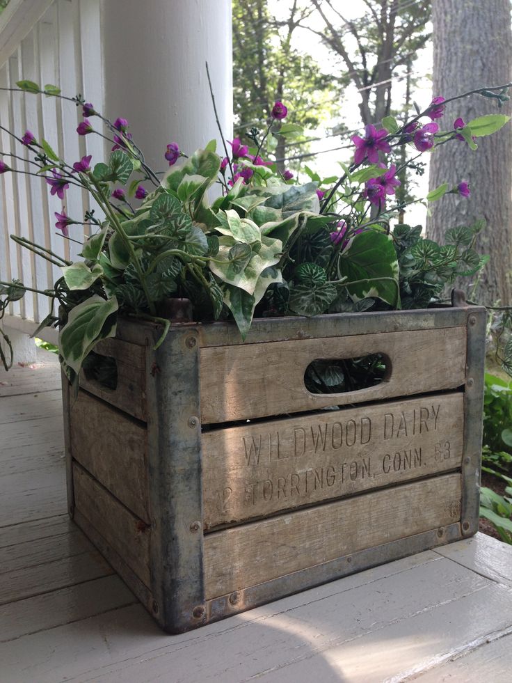 a wooden box with plants in it sitting on the porch