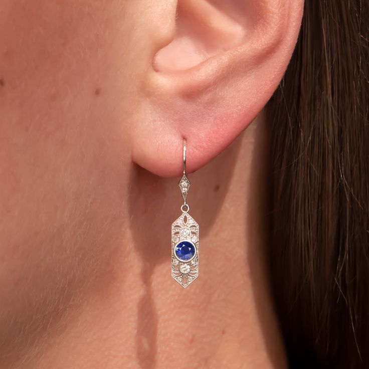 These elegant and brilliantly sparkling sapphire and diamond earrings bring the glamour with a chic and sophisticated Art Deco style design! The geometric settings are encrusted with diamonds and beautifully adorned with intricate cut outs and fine milgrain. The perfectly set off the rich blue sapphires. Graceful and luxurious, these timelessly glamorous and elegant earrings would make a splendid treat for yourself or an excellent gift for an anniversary or special occasion!The sapphires are a w Luxury Platinum Blue Earrings, Elegant Blue Earrings With Diamond Accents, Luxury Blue Platinum Earrings, Evening Earrings With Sapphire And Diamond Accents, Evening Sapphire Earrings With Diamond Accents, Sapphire Earrings With Diamond Accents For Evening, Fine Jewelry Sapphire Diamond Earrings, Sapphire Diamond Accented Earrings In Fine Jewelry, Elegant Sapphire Earrings (lab-created)