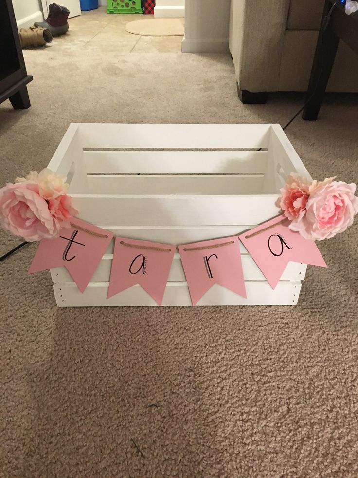 a white crate with pink paper flowers on it and the word tarq spelled out