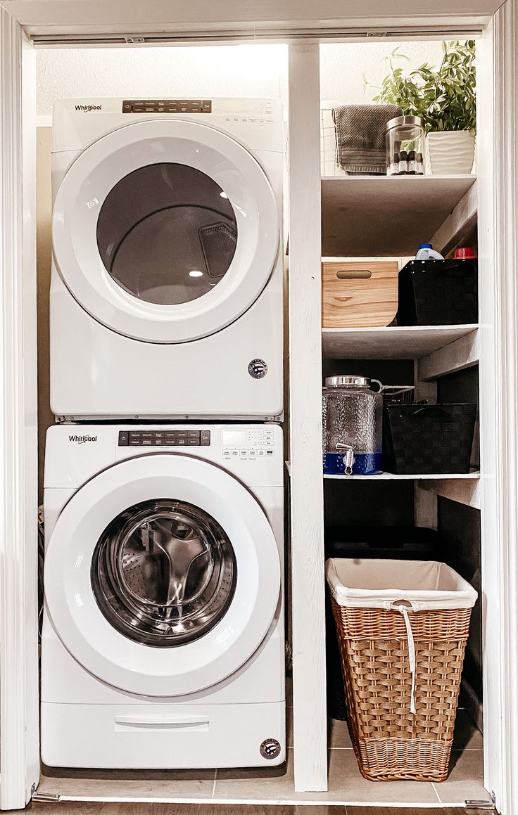 a washer and dryer sitting in a closet next to each other with baskets on the floor