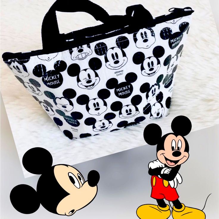 Disney Mickey Mouse Tote Lunch Bag 10.8”X3.9”X6.5”. - Material: Polyester, Expanded Polyethylene, Aluminum - Dry Inside Out After Use - Not Waterproof - Measures 10.8”X3.9”X6.5” Cheap Mickey Mouse Rectangular Bag, Disney Black School Bags, Disney Style Black School Bags, Black Rectangular Bags With Character Print, Playful Mickey Mouse Bags For Disney Trips, Disney Character Print Bags For Disney Trips, Black Disney Bags With Character Print, Black Disney Rectangular Bag, Black Mickey Mouse Bag For Disney Fan Events