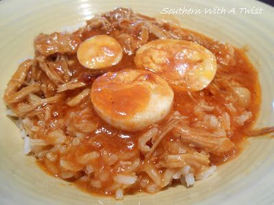 a white plate topped with rice and meat covered in sauce