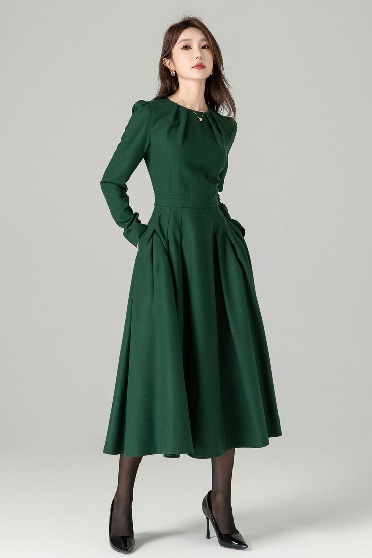 "Green long sleeve wool swing dress with a stylish folded neckline. This dress effortlessly blends elegance and comfort. The flared silhouette offers a graceful and flattering fit, while the high-quality wool fabric ensures warmth and softness. The folded neckline adds a touch of sophistication to this versatile dress, perfect for various occasions. DETAIL * 30% wool, 30% fiber, 40% polyester * fully satiny lining, more nice to the touch body * Round pleated neckline * Long sleeves * Fit and fla Long Sleeve Winter Wedding Midi Dress, Winter Wedding Long Sleeve Midi Dress, Elegant Full Skirt Dress For Fall, Long Sleeve Midi Dress For Fall Wedding, Fitted Long Sleeve Fall Wedding Dress, Fall Wedding Long Sleeve Midi Dress, Formal Long Sleeve Wool Dress, Chic Long Sleeve Dress For Fall Wedding, Fitted A-line Long Sleeve Pleated Dress