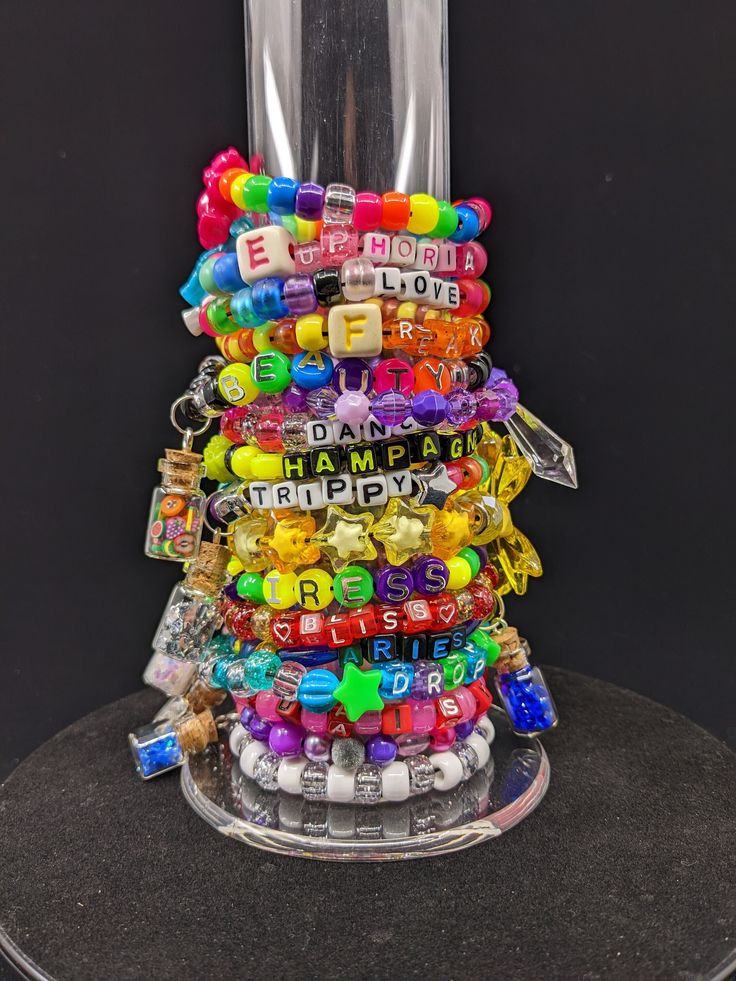 BRACELETS ARE ASSORTED SIZES FROM 6.5-9IN CIRCUMFRENCE -Kandi bracelets featuring handmade glass vial charms -Made with elastic cord -You will receive all the bracelets pictured -You will receive exactly what's pictured in the photos -For bracelets with charms they are made of GLASS and can break.  They are removable from the kandi via double jump ring if you don't wish to wear them.  Vials are glued shut and aren't openable. -Handmade pony bead kandi bracelets -Majority of bracelets are made with traditional pony beads, but some bracelets include mini beads, round acrylic, tri beads, etc. -These bracelets are premade and not customizable.  -Made with black elastic cord, not clear crystal string. -Please note that bracelets in this lot vary in size.  Shipping within the US USPS First Class Bead Kandi, Bracelets With Charms, Rave Bracelets, Funky Shirts, Kandi Ideas, Glitter Rainbow, Kandi Bracelets, Glass Vials, Pony Beads