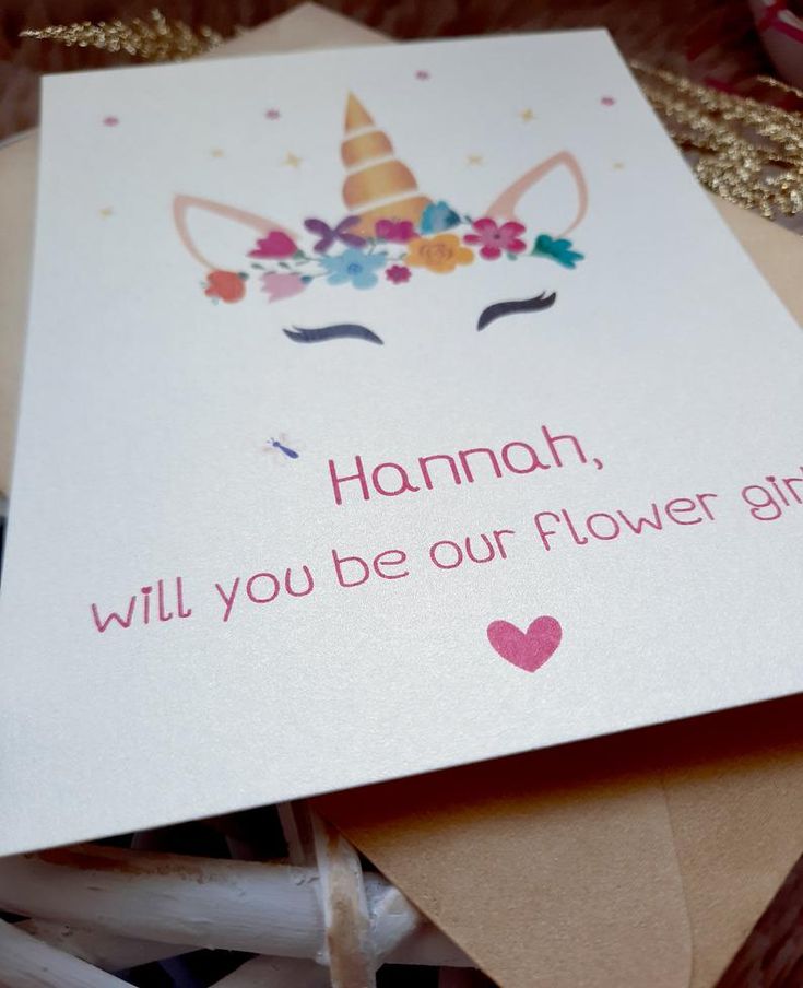 a card that says hannah will you be our flower girl? with an unicorn's head on it