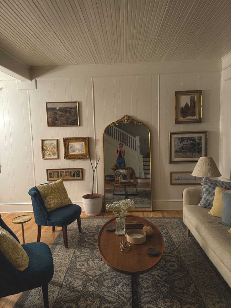 a living room filled with furniture and a large mirror