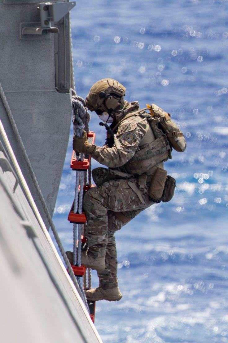 a man climbing up the side of a boat