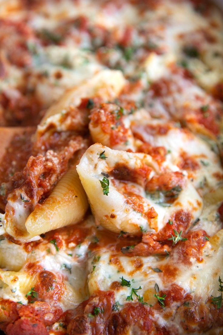 a close up of a plate of pasta with sauce and cheese