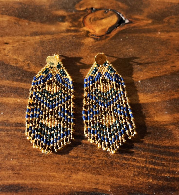 Handmade beaded tassel earrings  Blue, teal, bronze and gold beads combine together to form these beautiful tassel dangle earrings Blue Tassel Earrings With Round Beads, Artisan Gold Beaded Earrings, Traditional Blue Beaded Fringe Earrings, Elegant Turquoise Beaded Earrings With Gold Beads, Blue Gold Beaded Drop Earrings, Artisan Gold Earrings With Beaded Fringe, Artisan Beaded Fringe Earrings For Jewelry Making, Gold Artisan Beaded Fringe Earrings, Blue Dangle Chandelier Earrings With Latkans