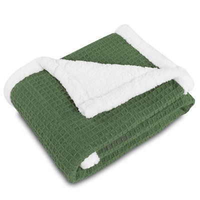 the green and white blanket is folded up