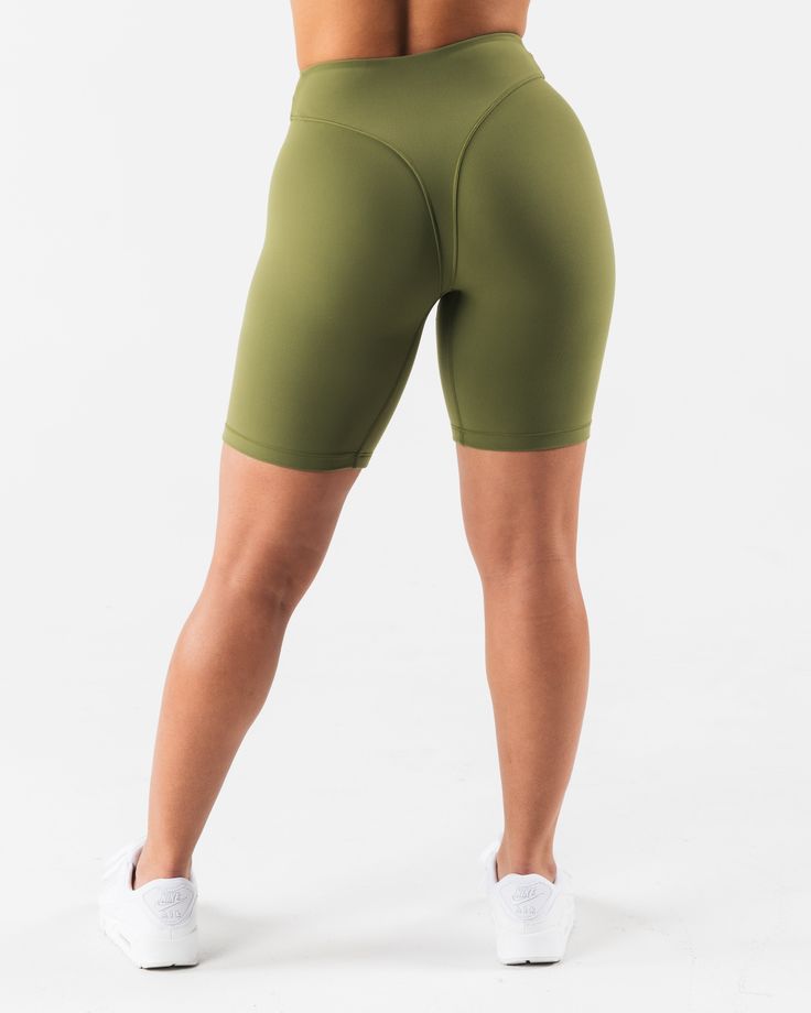 HIGHLIGHTS. 7" inseam High rise Buttery soft High sweat FIT SUGGESTION. This item runs true to Alphalete's tight fit... Brittney is 5’2”/157.5cm, wearing a size S. with 26"/66cm waist and 37"/94cm hips. MATERIALS AND WASHING DIRECTIONS. 70% Nylon, 30% Spandex. We recommend washing inside-out on a cold setting. Hang to dry DESCRIPTION Extreme high stretch meets a buttery soft hand-feel to make this fabric the perfect ten. No front seam and a double layer front panel, for added compression and com Athleisure Fitted Leggings With Built-in Shorts, Fitted Biker Shorts With 5-inch Inseam For Gym, Sporty Fitted Biker Shorts With 5-inch Inseam, Bottoms With Built-in Shorts For Light Exercise, Fitted Bottoms For Light Exercise, Mid-thigh Length, Fitted Biker Shorts With Moisture-wicking, 5-inch Inseam, High Stretch Green Workout Shorts, Green Fitted Training Bottoms, Fitted Green Training Bottoms