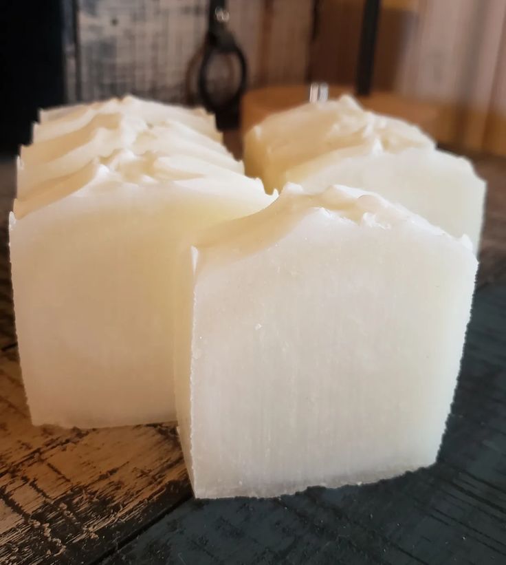 three pieces of soap sitting on top of a wooden table