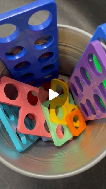 a metal bowl filled with different colored plastic blocks