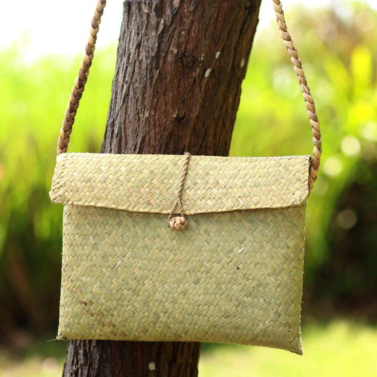 Add a natural look to your ensemble with this woven shoulder bag from Balinese artisan team Dewa Brothers. Crafted from woven water hyacinth reeds the bag features a woven pattern in a natural color a long strap that fits comfortably on your shoulder and a simple yet elegant flap closure secured with a single button.