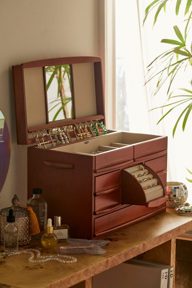 a wooden jewelry box sitting on top of a table next to a potted plant