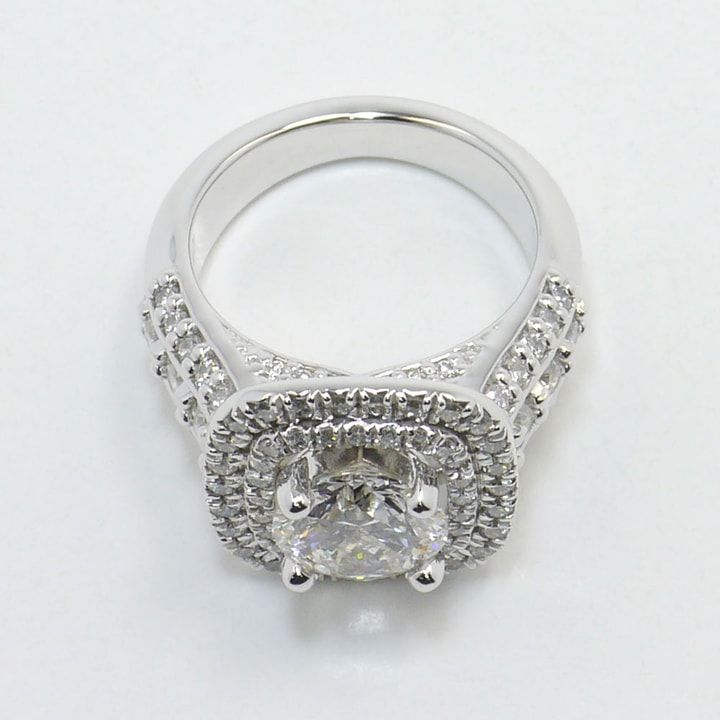 a white gold engagement ring with an oval cut diamond surrounded by pave set diamonds