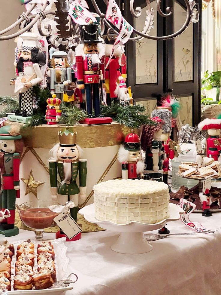 a table topped with lots of food and christmas decorations next to a cake on top of a plate