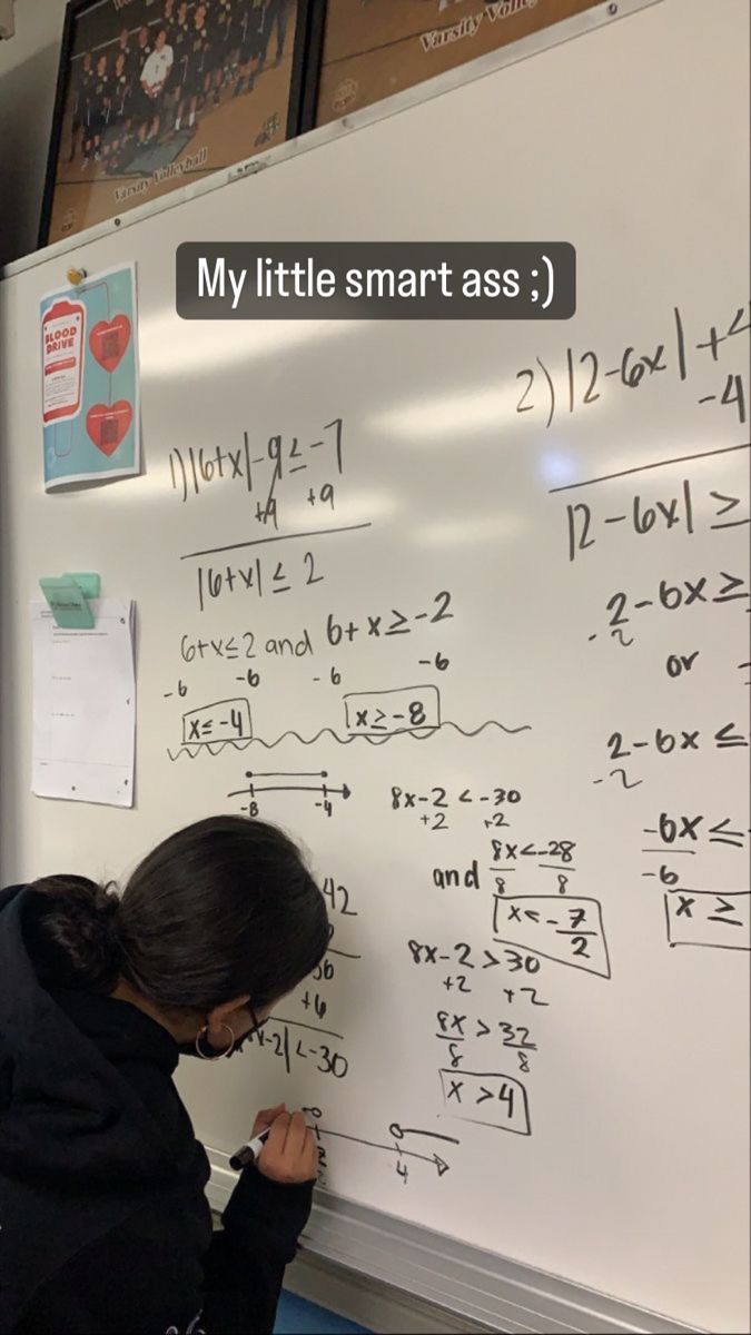 a woman writing on a white board with numbers