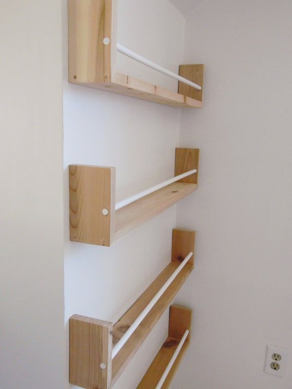 three wooden shelves mounted to the side of a wall next to a white painted wall