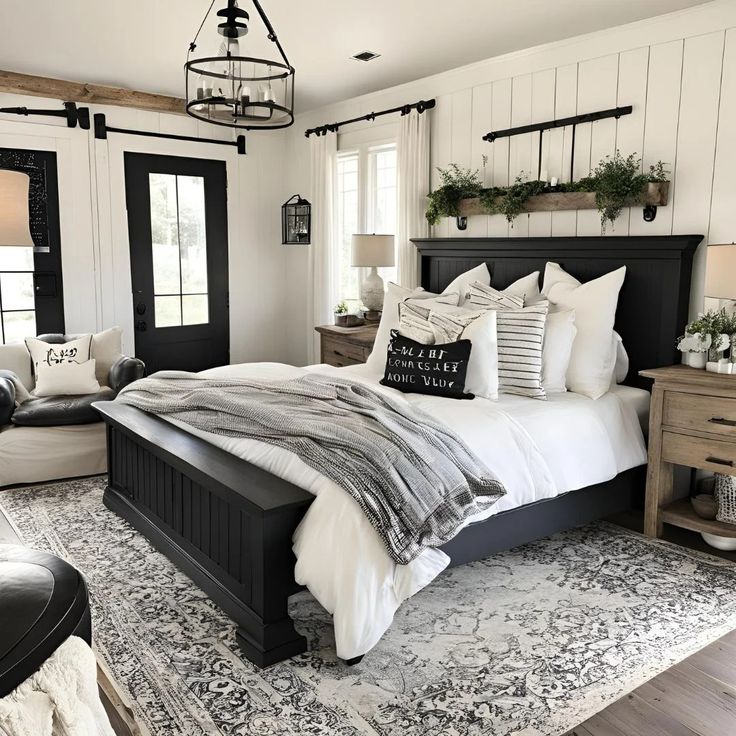 a bedroom with black and white bedding, pillows and rugs on the floor