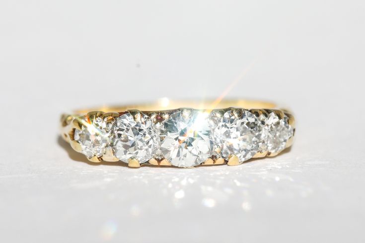 a three stone diamond ring on a white surface