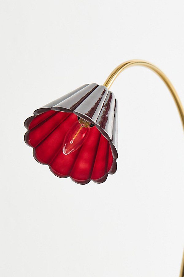 a red and silver lamp with a white background