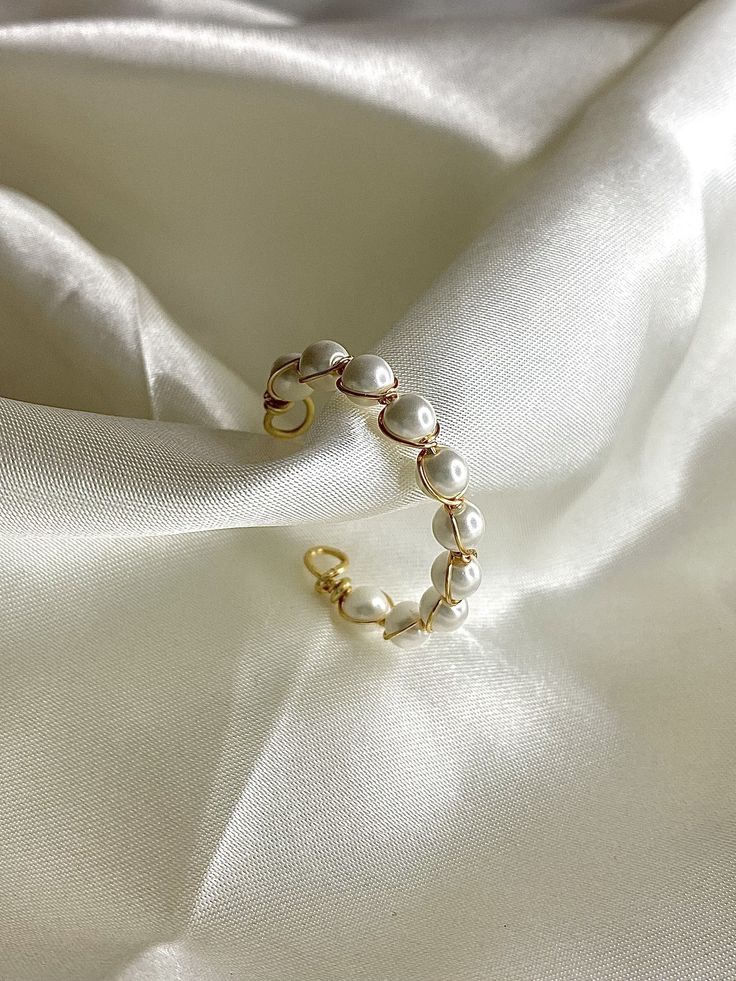 This natural shell pearl ring is stylish and cute, it deserves a place in everyone's jewellery box. The beautiful detail and distinctive charm of this ring will ensure that it can be accessorised infinitely with any outfit. Benefits: This ring is completely adjustable and features 18k gold wrapped wire. Description: 17.5mm, completely adjustable. One size fits most Adjustable Rose Gold Open Pearl Ring, Trendy Gold Pearl Ring Gift, Elegant Pearl Toe Ring As Gift, Elegant Pearl Toe Ring For Gift, Adjustable Minimalist Pearl Ring, Trendy Adjustable Pearl Ring, Pearl White Open Ring Pearl Jewelry, Minimalist Pearl White Pearl Ring, Elegant White Rings As A Gift For Her