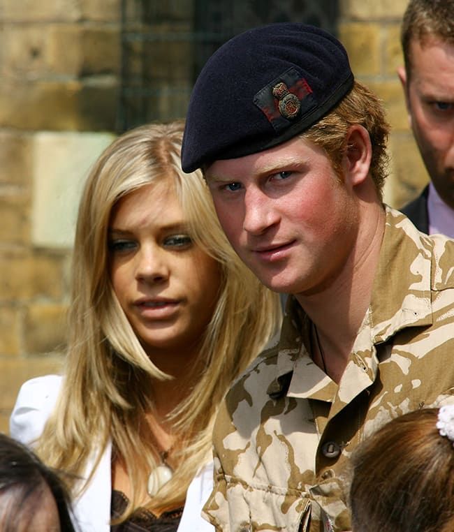 a man in uniform standing next to a woman wearing a beret and looking at the camera