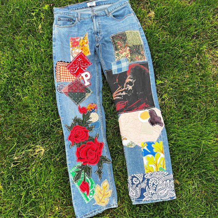 an old pair of jeans with patches and flowers on them laying in the green grass