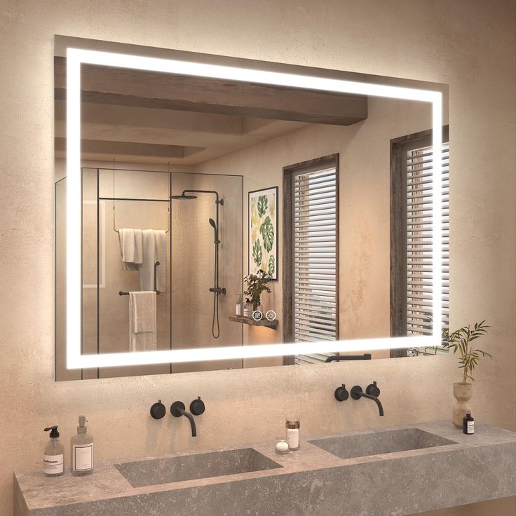 a bathroom with two sinks and a large mirror over the sink that has lights on it