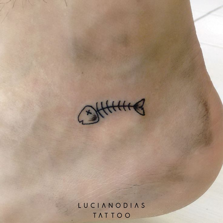 a small fishbone tattoo on the side of someone's lower leg and foot