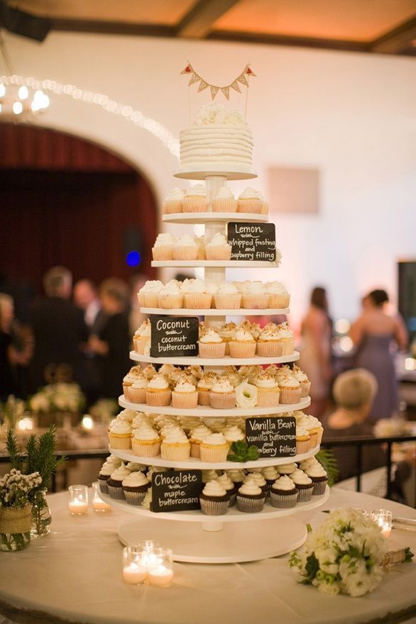 a wedding cake with cupcakes on it