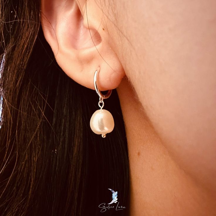 Experience luxury and elegance with these Baroque pearl drop hoop earrings. Made with solid 925 sterling silver and available in platinum or 18k gold plating, these earrings feature a unique, irregular-shaped freshwater cultured pearl. Add this delicate and stylish piece to your everyday jewelry collection or gift it to a loved one.Sold as a pairMaterials: 925 sterling silver, freshwater pearlFinish: platinum plate, gold plateInner hoop diameter: 0.36 in (9.1 mm) Jewelry Care: See more information about how to care for your jewelry here. Shipping Policy: Orders will be shipped within 1-3 business days. Economy shipping will take 7-14 days to arrive and standard shipping is 1- 4 days for U.S. orders. International shipping time is depended on the country and per shipping method. Shipping co Sterling Silver Drop Pearl Single Earring, Pearl Drop Dangle Huggie Earrings, Elegant Pearl Huggie Hoop Earrings, Sterling Silver Pearl Pendant Earrings, Elegant Hoop Earrings With Pearl Pendant, Dainty Sterling Silver Earrings With Pearl Pendant, Pearl White Sterling Silver Earrings With Pearl Charm, Pearl Pendant Huggie Earrings, Classic Silver Huggie Pearl Earrings