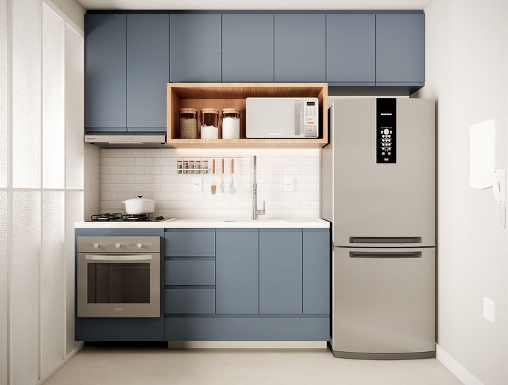 a modern kitchen with blue cabinets and white counter tops is pictured in this image, there is a stainless steel refrigerator next to the sink