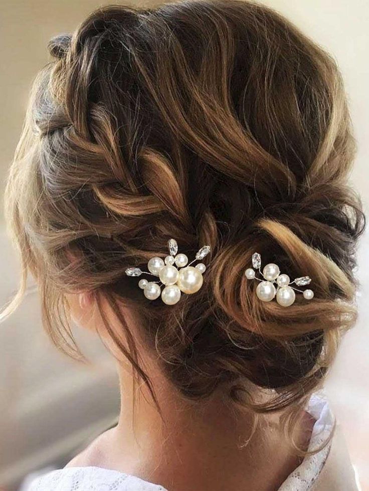 a woman wearing a wedding hair comb with pearls on the side and two pieces of hair in