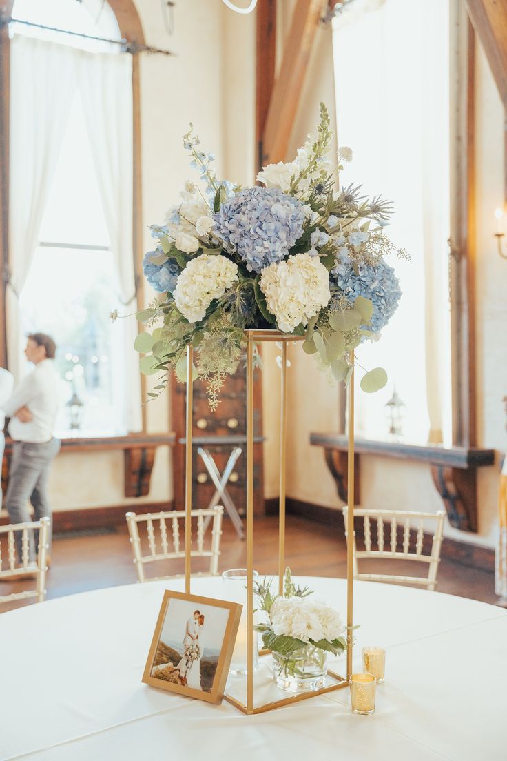 a wedding centerpiece with blue and white flowers