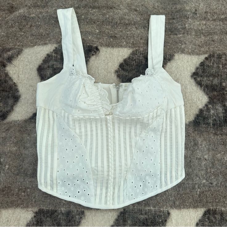 With Jean Layla Bustier Eyelet Top Size Small. Zips In Back. 100% Cotton. I Bought On Depop Brand New And Never Wore It. Seller Removed Tags. Unfortunately I Couldn’t Fill The Bust. White Cropped Crop Top With Boned Bodice, Fitted Underbust Crop Top For Summer, Chic Cropped Cotton Corset, White Crop Top Corset For Summer, White Cropped Crop Top With Removable Bra Pads, Summer Cropped Crop Top With Boned Bodice, White Cropped Top With Boned Bodice, Boned Bodice Cropped Crop Top For Summer, Spring Underbust Corset With Removable Bra Pads