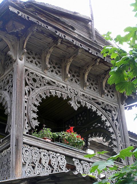 an ornate wooden building with flower boxes on the balcony